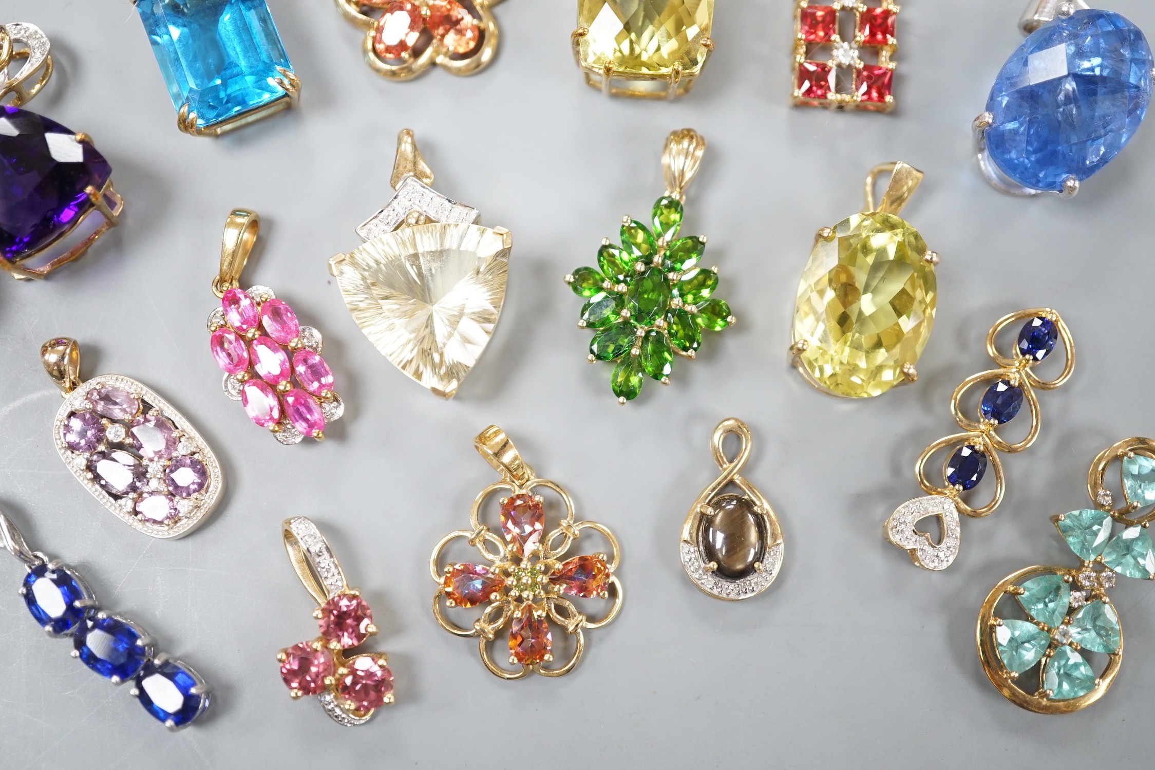 Nineteen assorted modern 9ct gold or yellow metal and gem set pendants, including citrine and amethyst and a 9ct gold chain, gross weight 63.6 grams.